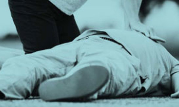 A close up of a person delivering CPR to someone laying on the floor