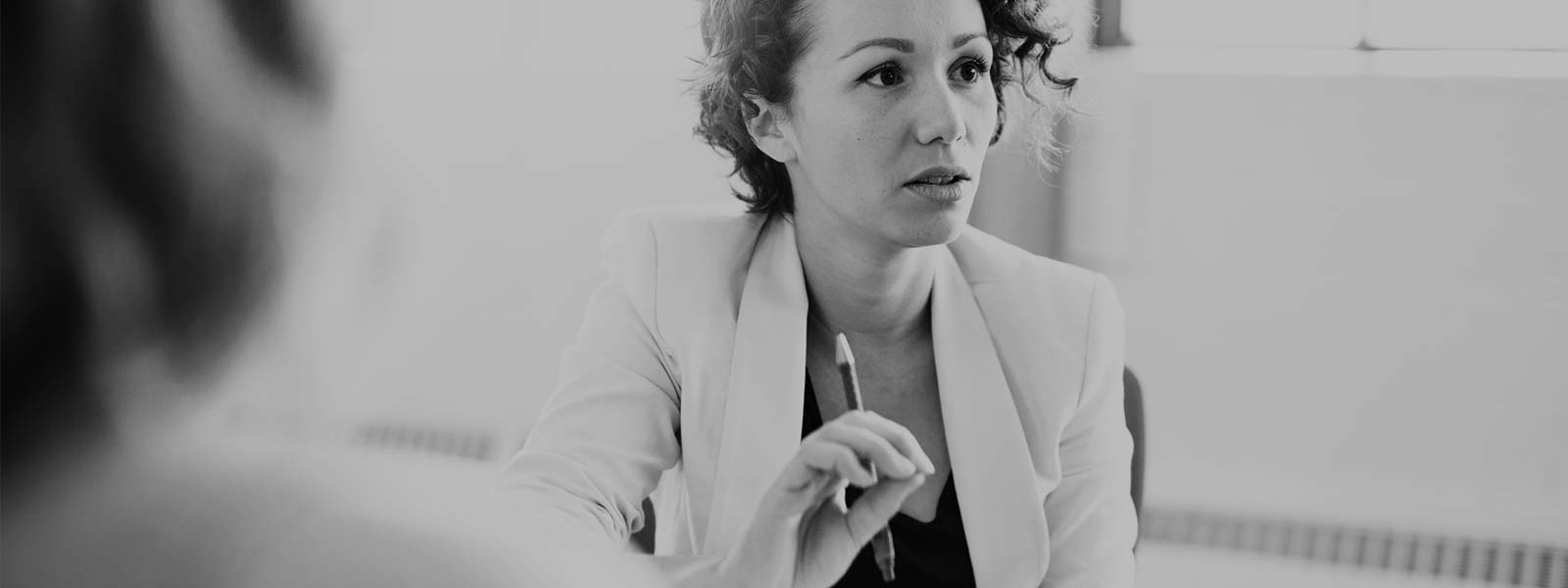 A person with a pencil in their hand speaking