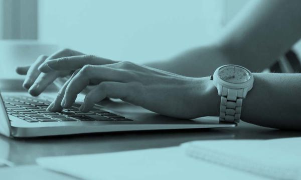 Woman's hands typing on laptop at workplace 