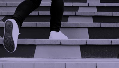 Feet walking up concrete steps