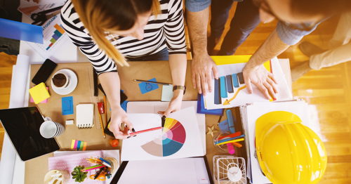 Two office workers looking at a pie chart