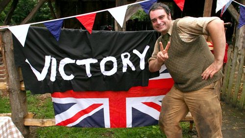 Man standing next to a victory sign