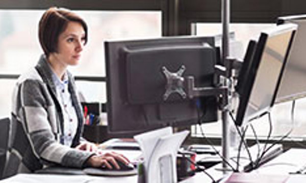 Person sat at an office desk looking at a computer screen