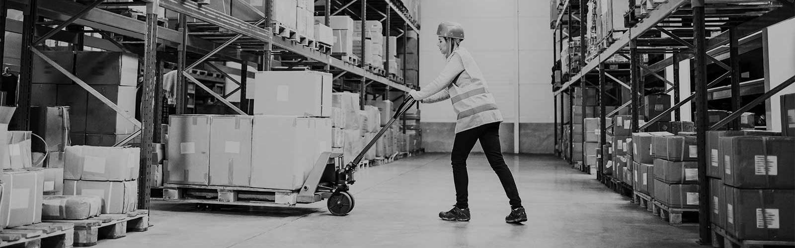 A person pushing a manual pallet truck