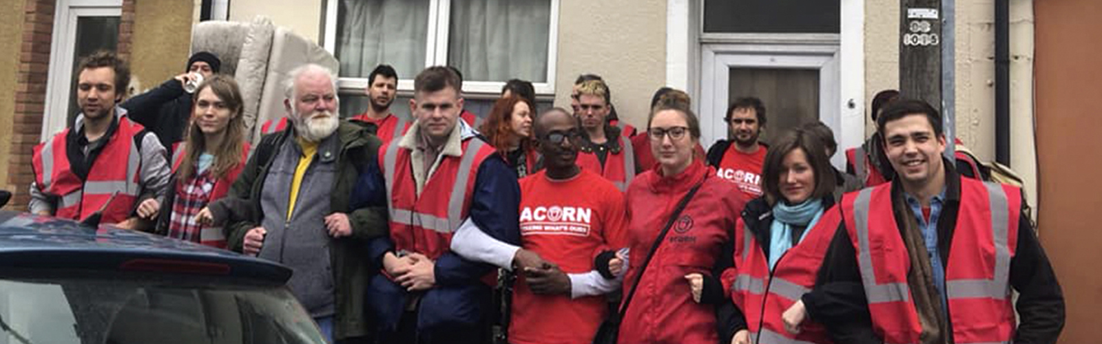 Housing campaigners in high-vis, standing in a line