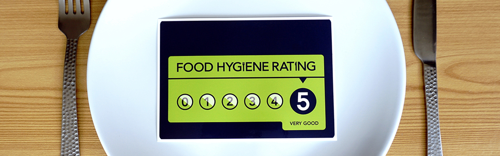 Food hygiene rating scheme sticker on a plate with cutlery at the sides