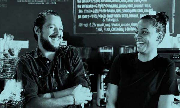 A man and a woman laughing in a cafe