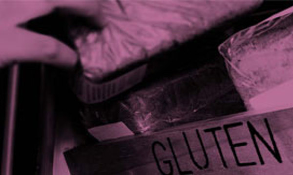 A close up of a loaf of gluten free bread being taken from a shelf