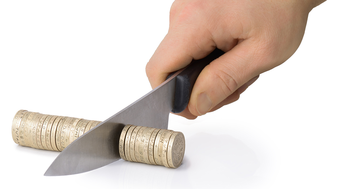 A knife cutting through a row of £1 coins
