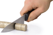 A knife cutting through a row of £1 coins