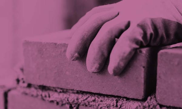 A hand laying a brick