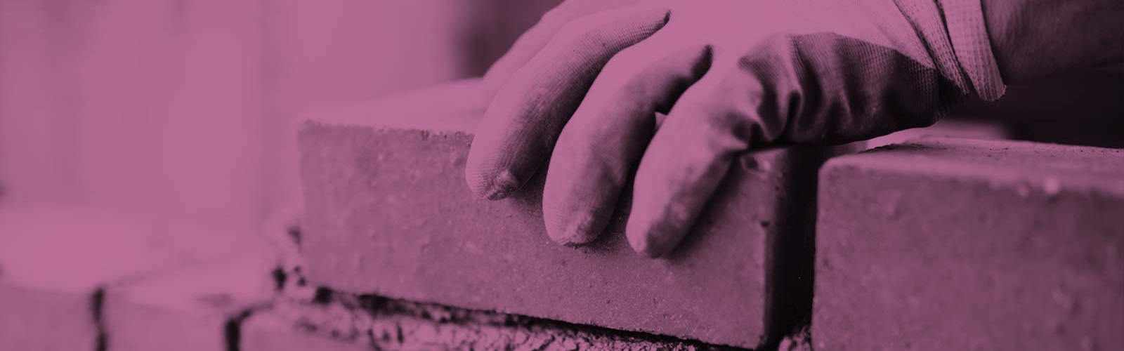 Hands laying bricks 