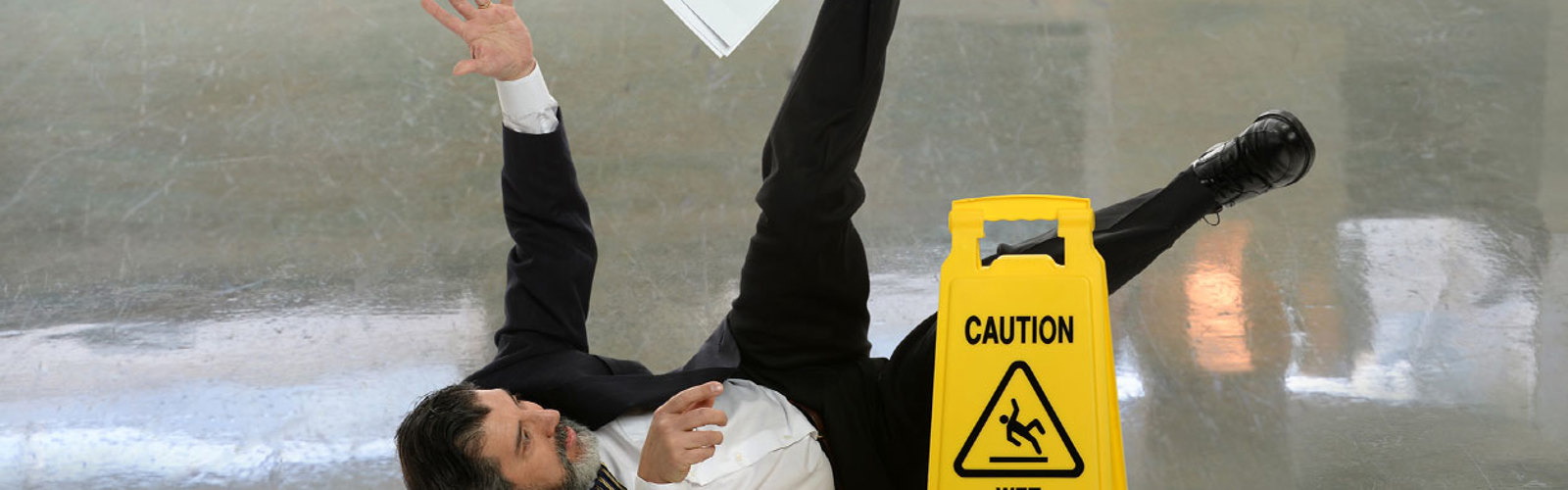 Man falling over and a 'Caution: Wet floor' sign