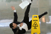 Man falling over and a 'Caution: Wet floor' sign