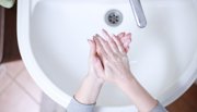 person washing hands in sink 