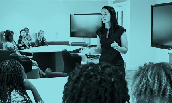 A person presenting to a classroom of people