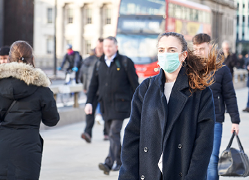 Women wearing mask on busy street 