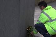 A protester placing flowers at the 'Unknown construction worker' statue in London