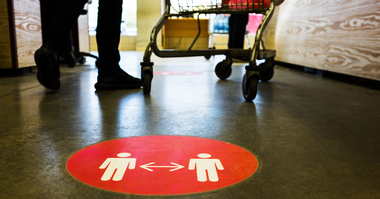 A 2m distancing sign on the floor of a supermarket