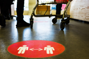 A 2m distancing sign on the floor of a supermarket