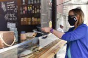 A woman pays with her phone at an outdoor coffee shop