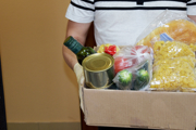 A food parcel being delivered by a person wearing plastic gloves.