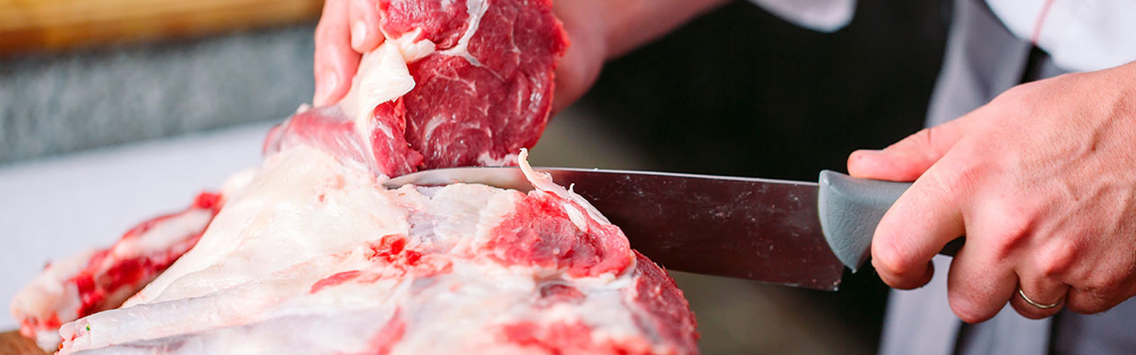 Close up of Butcher's hands cutting meat