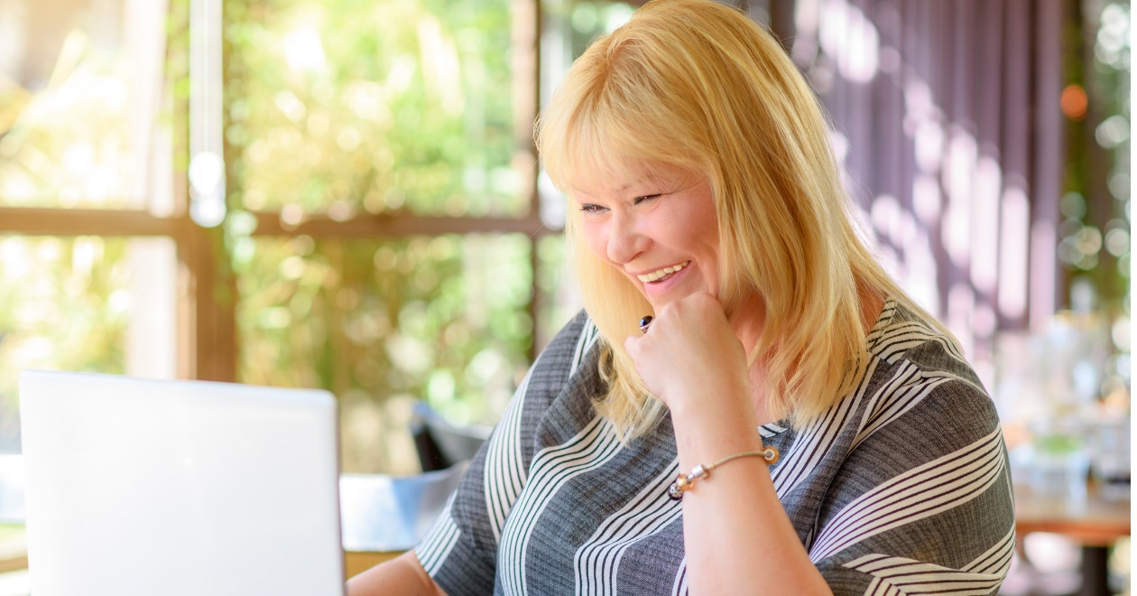 Woman looking at laptop smiling