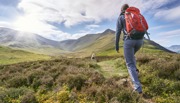 Person with backpacking walking on mountainous land