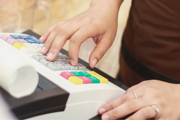 Close-up of hands using a cash register.