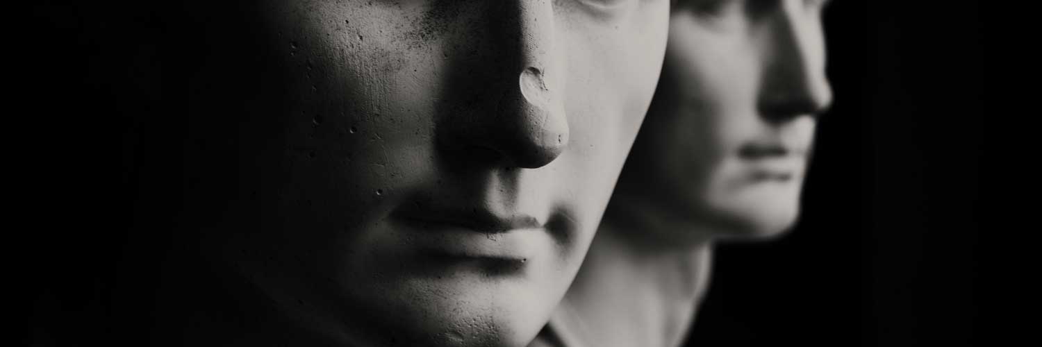 Two marble busts. The one in the foreground has a big chip in its nose. 