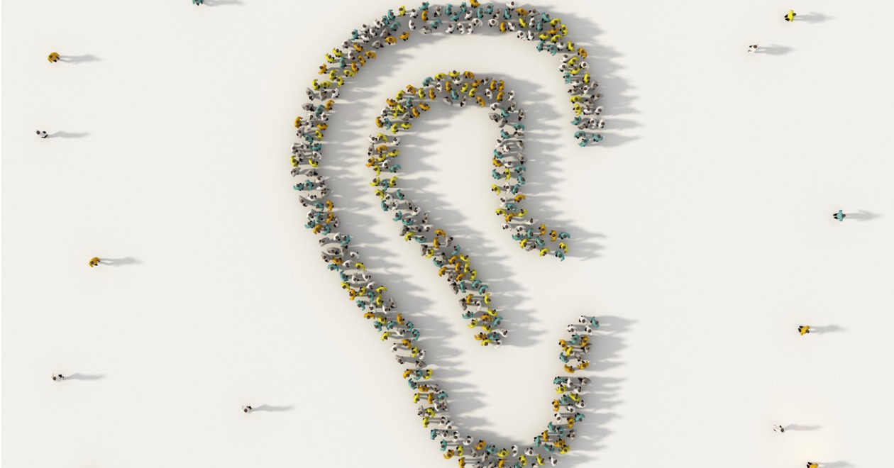 Large group of people forming an ear symbol