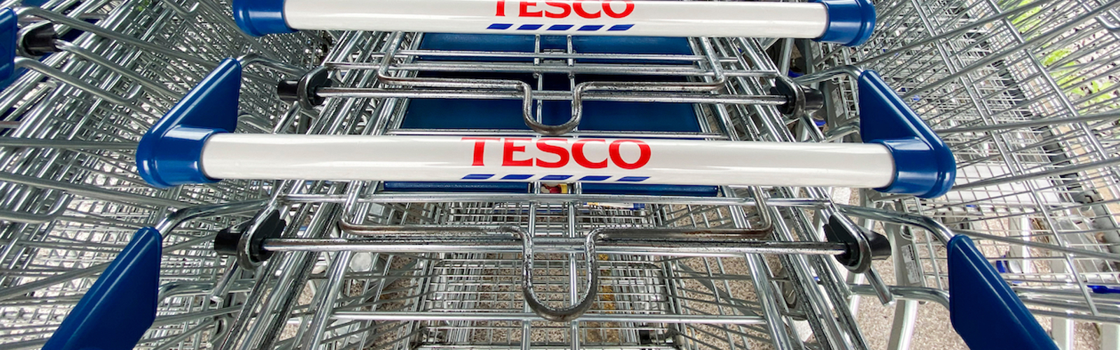 A stack of supermarket trollies with the Tesco logo on their handles