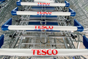 A stack of supermarket trollies with the Tesco logo on their handles