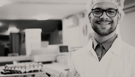 Man in a lab coat holding egg boxes