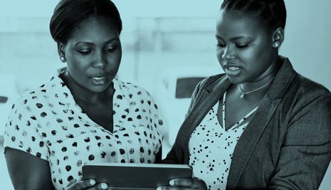 Two woman in conversation looking at a tablet