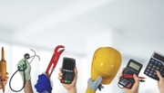 Hands holding up tools and equipment including a stethoscope, hard hat and a calculator