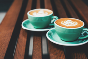 Green coffee cups sat on a wooden table