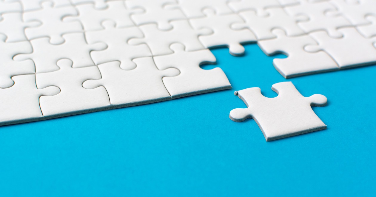 White jigsaw piece completing the puzzle on blue background