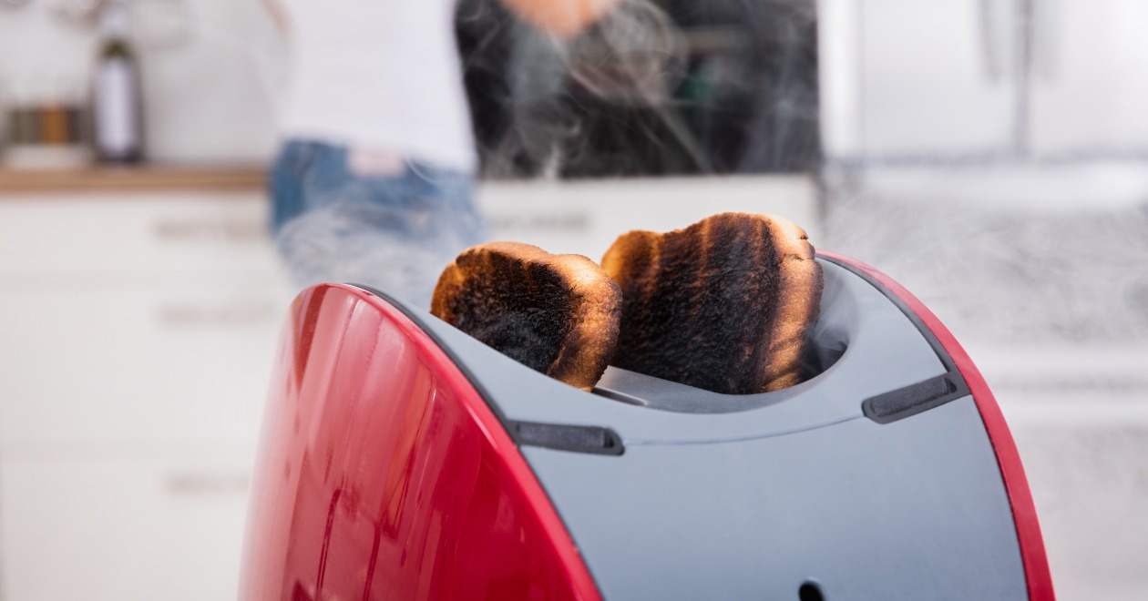 Burnt toast rising out of red toaster