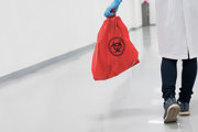 Person carrying a bag of medical waste