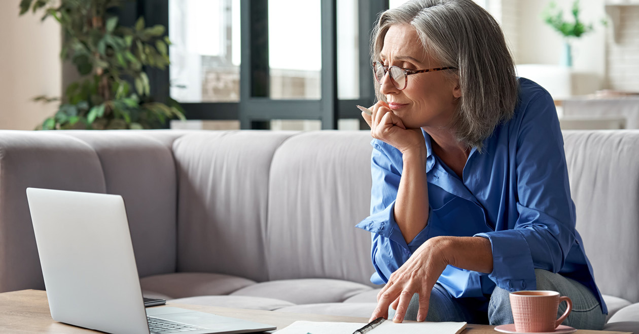Woman sitting looking at her laptop screen