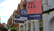 Row of houses with to let boards displayed outside