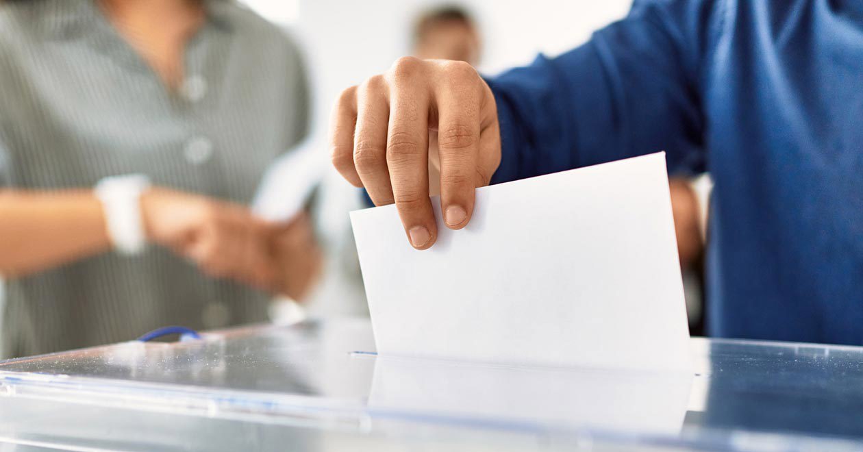 A man drops his vote into a ballot box