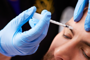 Botox being injected into mans forehead
