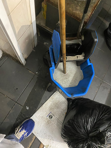 Photo of a mop and bucket and rubbish bag
