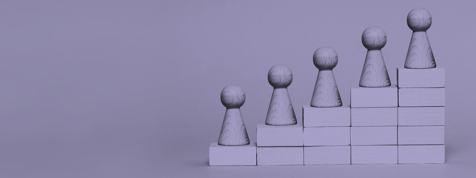Wooden stairs representing membership grades, with a wooden figure on each step