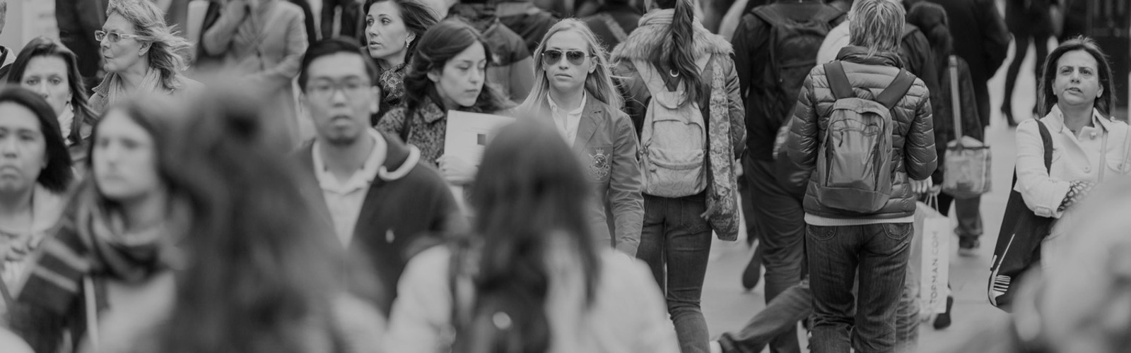 Lots of people walking on a crowded pavement 