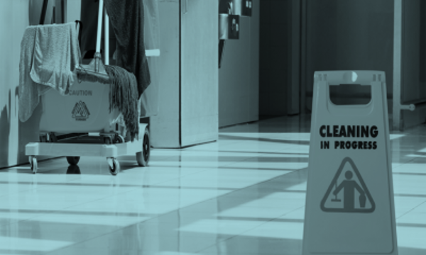 A commercial mop and bucket and cleaning in progress sign